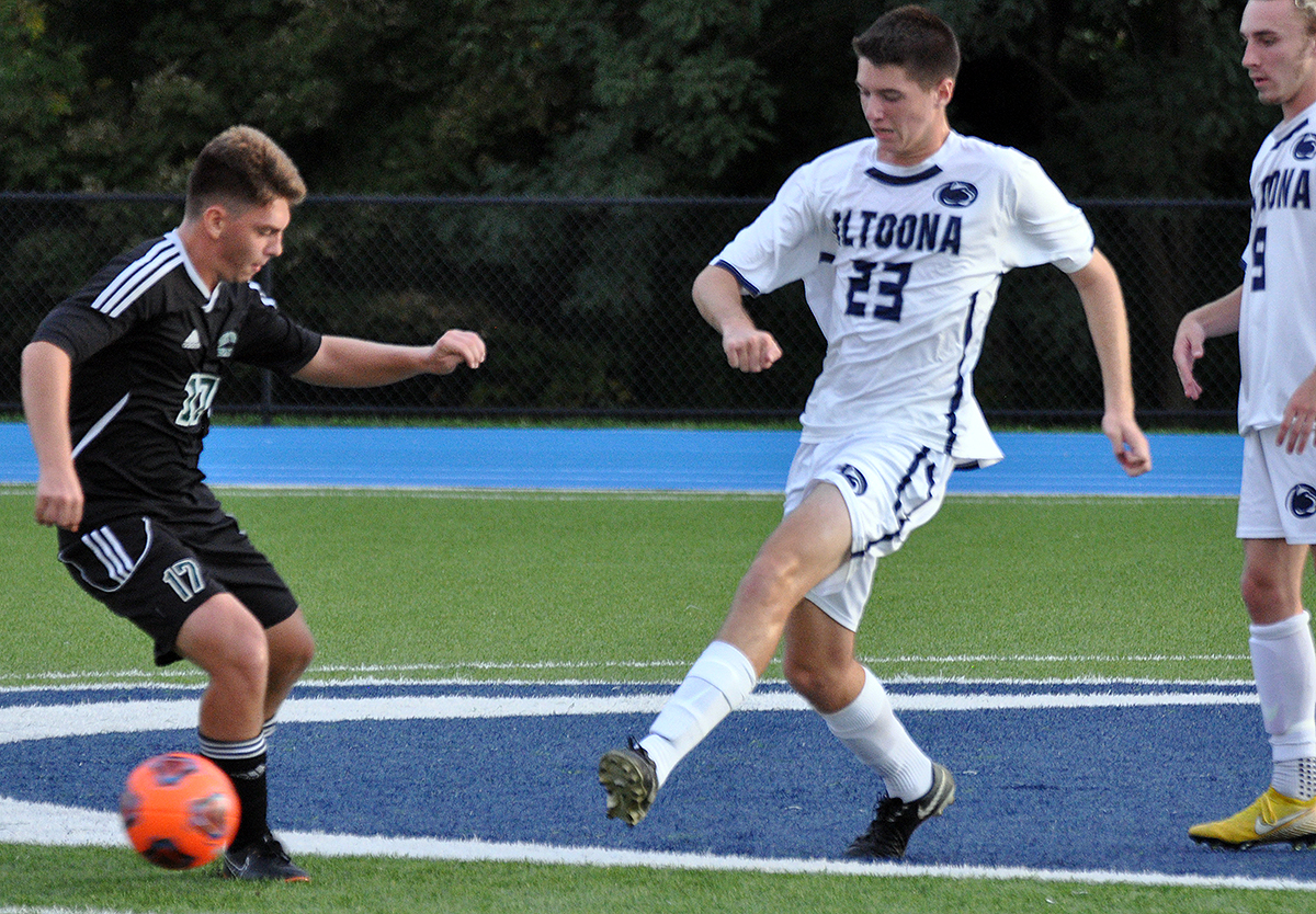 Photo (by Joel Nelson): Penn State Altoona's Connor Kiley chips the ball past St. Vincent's #17 Griffin Prinkey during Thursday night's game at Spring Run Stadium.