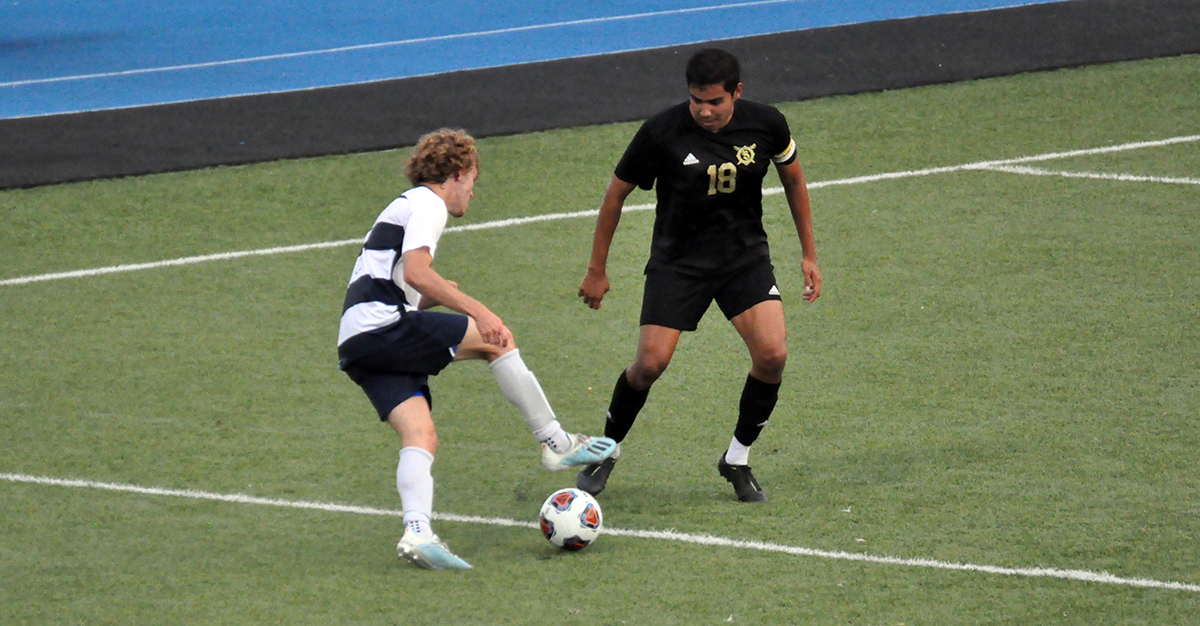 Photo: Sophomore Brant Aughenbaugh dribbles in front of a Franciscan player during Tuesday's game.