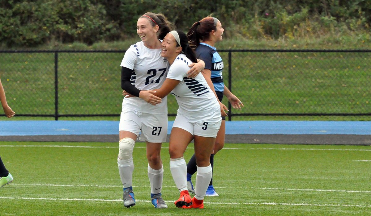 Photo (by Omer Sanchez): Kierra Irwin and Sarah Huston celebrate after a goal during the Lady Lions' win over Medaille on Saturday.
